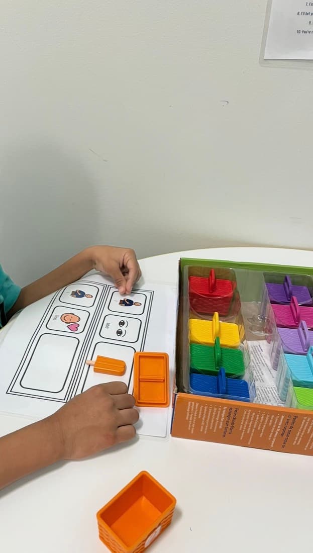 Hands using play materials during speech therapy